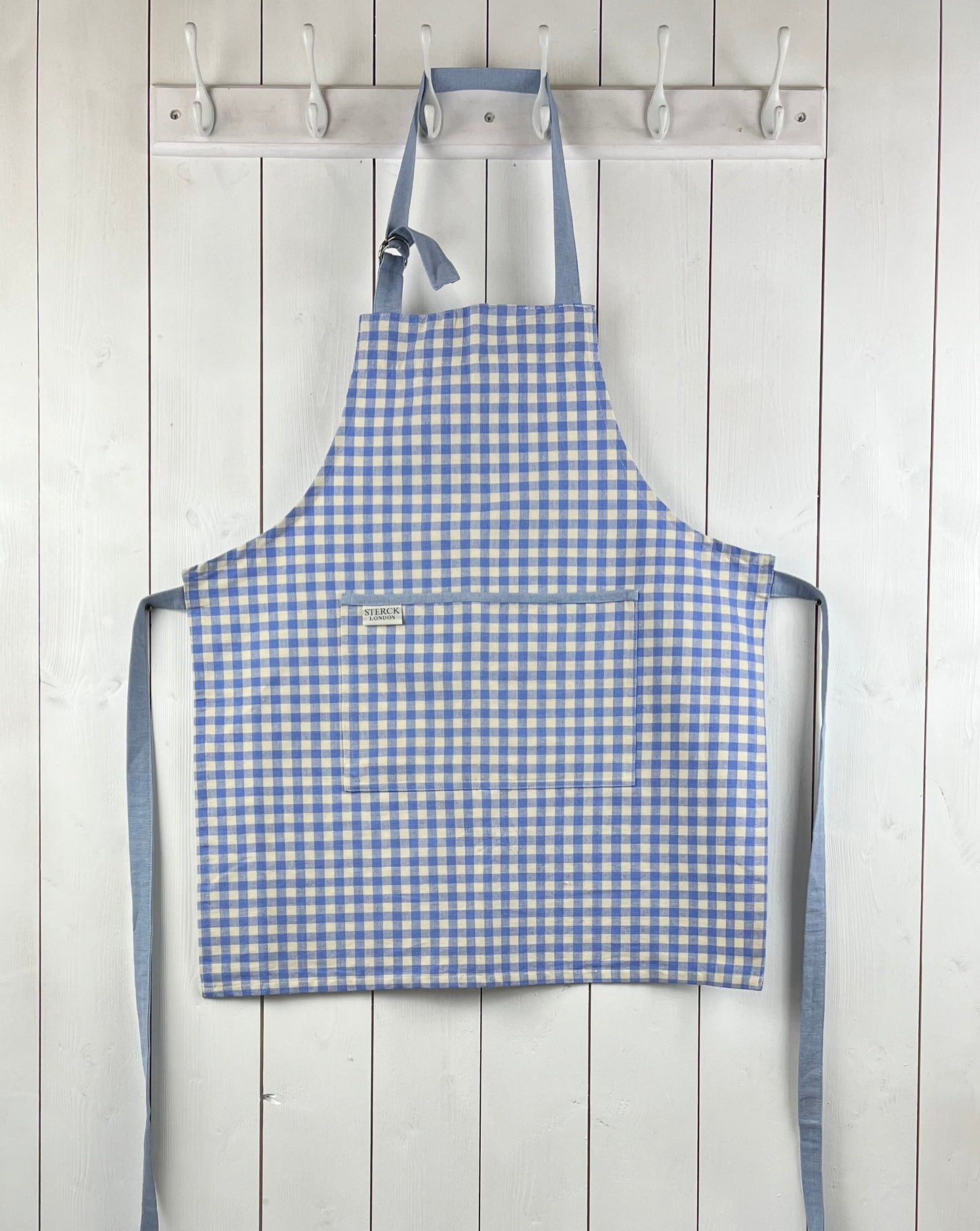 Blue gingham apron for children with large front pocket and adjustable neck strap. TurQuaz.