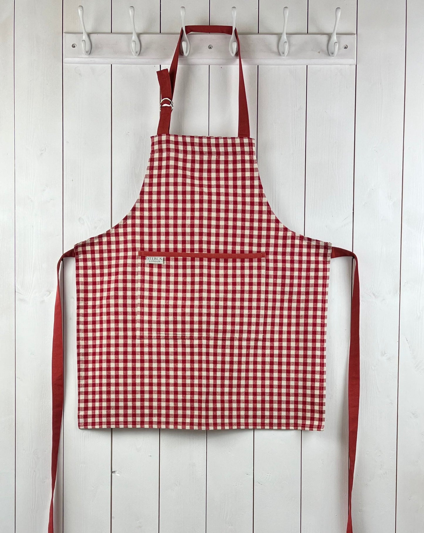 Red gingham apron for children with large front pocket and adjustable neck strap. TurQuaz.