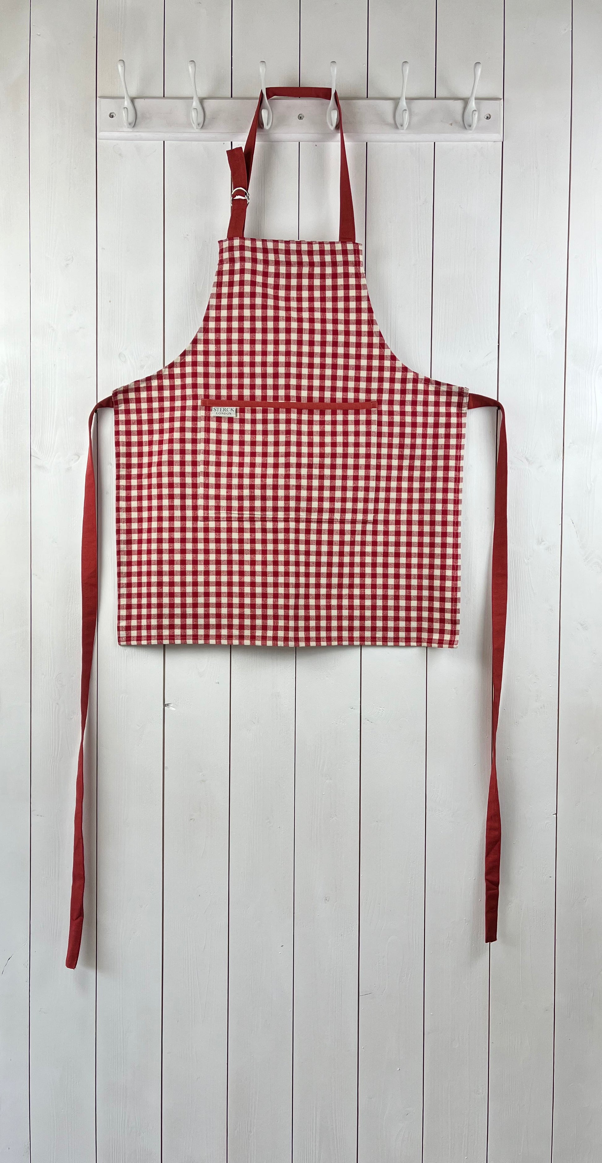 Red gingham apron for children with large front pocket and adjustable neck strap. TurQuaz.